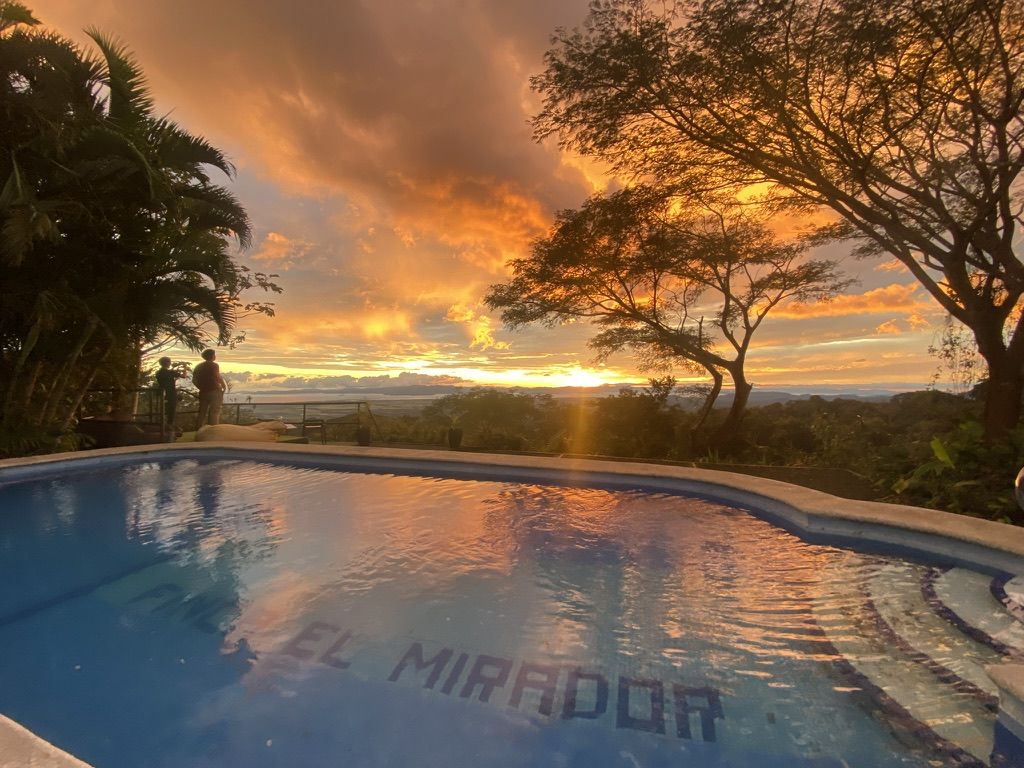 Piscina de la finca al atardecer, con el Golfo de Nicoya al fondo