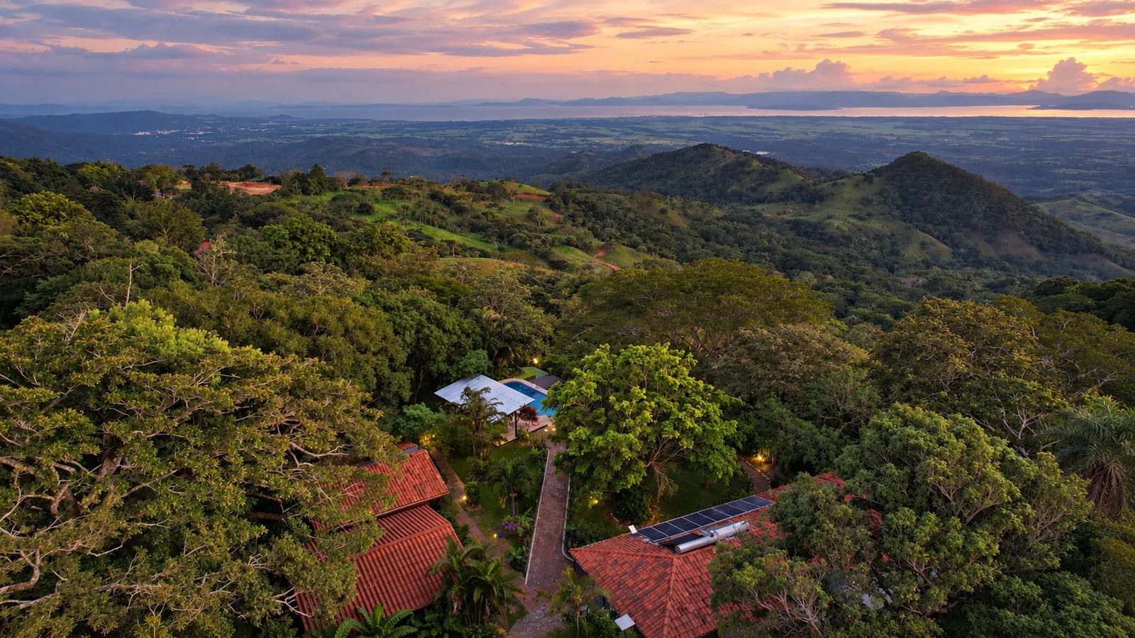 Vista aérea de la finca con el salón, la piscina y el Golfo de Nicoya al fondo